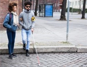 Blind man receives help crossing the street.jpg