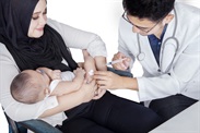 Mom holding infant while infant receives vaccine 