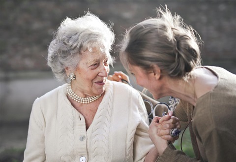 two women looking at each other holding hands